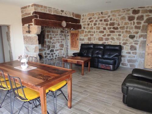 un salon avec une table et un canapé en cuir dans l'établissement Farmhouse in Ardèche near Vallon Pont d'Arc, à Sanilhac
