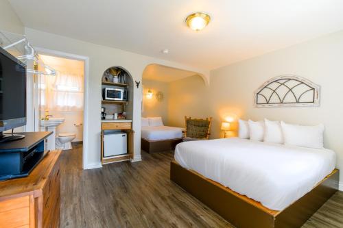 1 dormitorio con 1 cama blanca grande y baño en Dew Duck Inn, 