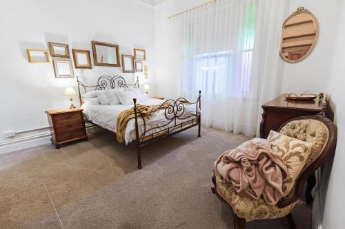 ein Schlafzimmer mit einem Bett, einem Stuhl und einem Tisch in der Unterkunft Noble View in Bairnsdale