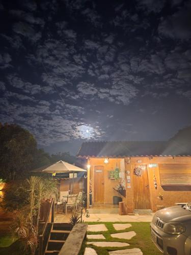 a house at night with the moon in the sky at Confraria da Prata Flats in Pirenópolis