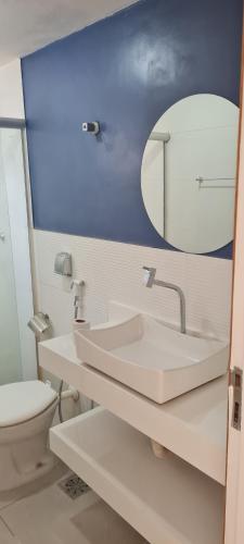 a bathroom with a sink and a toilet and a mirror at Ap aconchegante a 150 mts da praia de Itapoã in Vila Velha