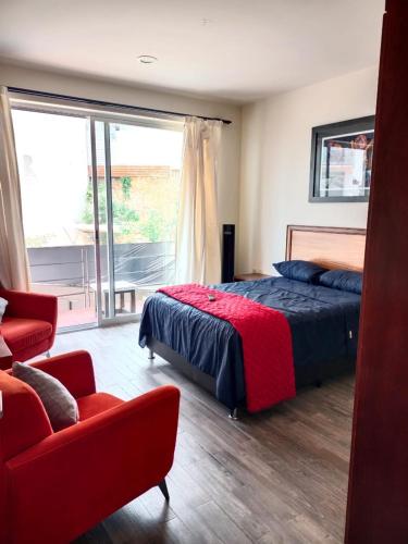 オアハカにあるCasa del Pibe Piolaのベッドルーム1室(ベッド1台、ソファ、窓付)