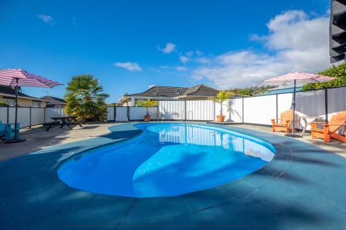 a swimming pool with blue water in a yard at ASURE Fountain Resort Motel in Nelson