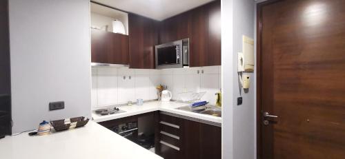 a small kitchen with a sink and a microwave at José Miguel Carrera Depto in Santiago