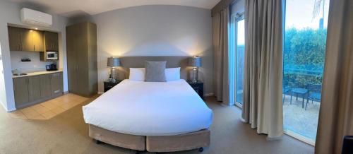 a bedroom with a large bed and a large window at Brooklands Of Mornington in Mornington