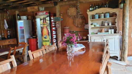 a dining room with a table and a refrigerator at Confraria da Prata Flats in Pirenópolis