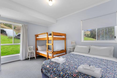 1 dormitorio con 1 cama y 2 ventanas en A Little Touch Of Paradise en Apollo Bay