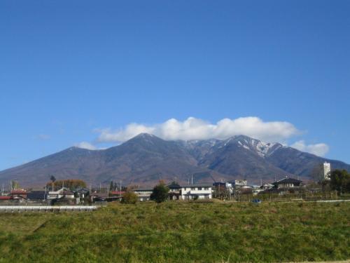 a mountain range in the distance with a town and houses at Pension Field in Hokuto