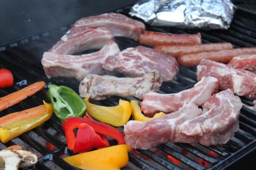 a bunch of meat and vegetables on a grill at Pension Field in Hokuto