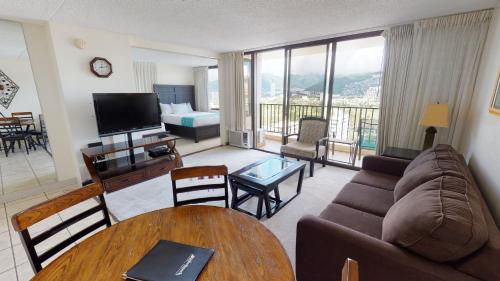 una sala de estar con sofá y una habitación con balcón. en One-Bedroom Apartment, en Honolulu