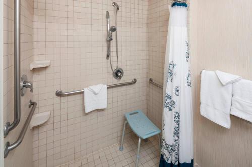 a bathroom with a shower with a blue stool in it at Residence Inn Tucson Airport in Tucson