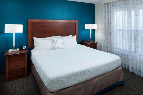 a large bed in a hotel room with two lamps at Residence Inn Tucson Airport in Tucson