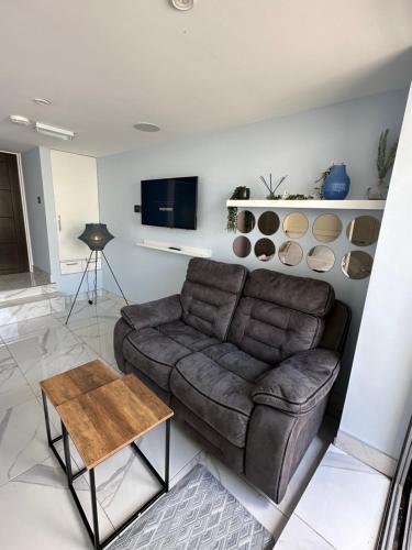 a living room with a brown couch and a table at Mara Boutique Apartaments in Oldbury