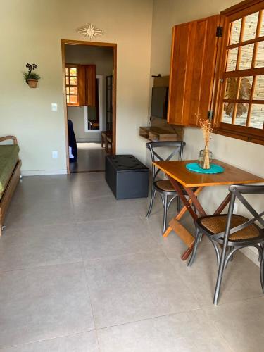 a living room with a table and chairs and a kitchen at Confraria da Prata Flats in Pirenópolis