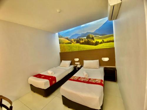 2 camas en una habitación con un cuadro en la pared en Best View Hotel Puchong, en Puchong