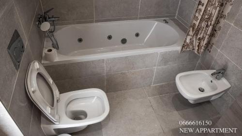 a bathroom with a toilet and a tub and a sink at New prestigia in Rabat