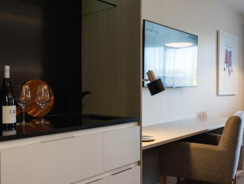 a kitchen with a counter with wine glasses on it at Porters Boutique Hotel in Havelock North