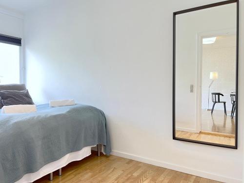 a mirror in a bedroom with a bed and a table at One Bedroom Apartment In Valby, Langagervej 64, 2 in Copenhagen