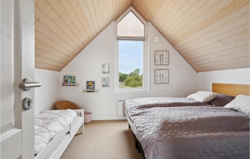 a attic bedroom with two beds and a window at Stunning Home In Nrre Nebel With Kitchen in Nørre Nebel
