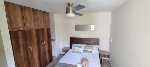 ein kleines Schlafzimmer mit einem Bett und einem Deckenventilator in der Unterkunft Apartamento Eje Cafetero - Cerca Parque del Café - Tebaida in La Tebaida