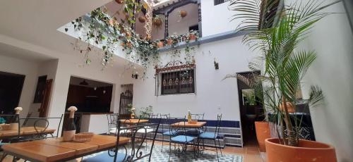 ein Zimmer mit Tischen, Stühlen und Pflanzen in der Unterkunft Villa del Prado in Medellín