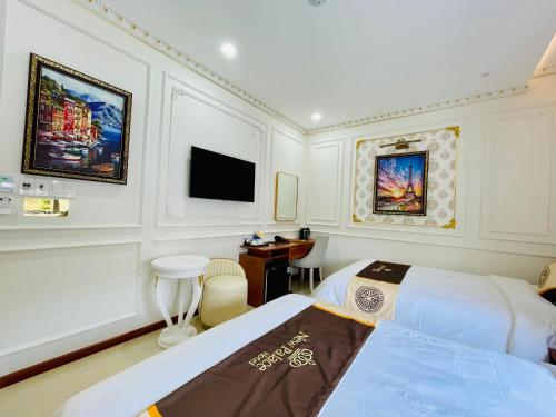 a hotel room with two beds and a television at NEW PALACE HOTEL in Quang Ngai