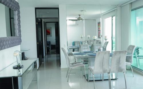 ein Esszimmer mit einem Tisch und weißen Stühlen in der Unterkunft Apartamento moderno y centrado en Barranquilla in Barranquilla