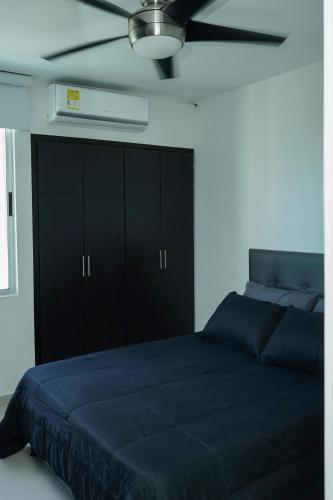 a bedroom with a blue bed and a ceiling fan at Apartamento moderno y centrado en Barranquilla in Barranquilla