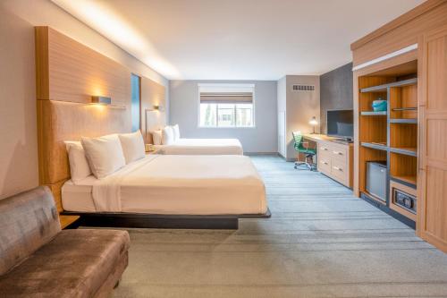 a hotel room with two beds and a couch at Aloft Cupertino in Cupertino