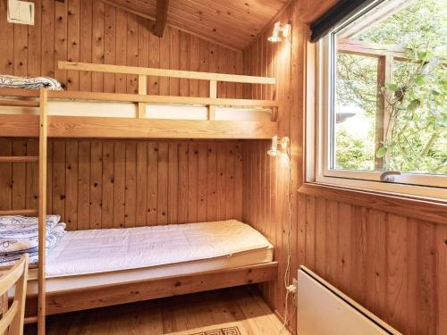 ein Schlafzimmer mit Etagenbetten in einer Holzhütte in der Unterkunft Holiday home Vordingborg XI in Vordingborg