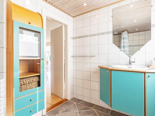 ein Badezimmer mit einem Waschbecken und einem blauen Schrank in der Unterkunft Holiday home Karrebæksminde IX in Karrebæksminde
