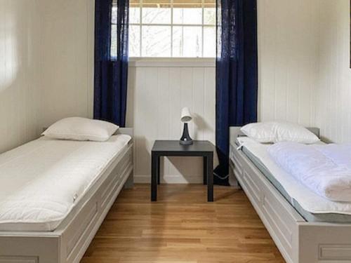 two beds in a room with a table and a window at Holiday home Tynset in Tynset