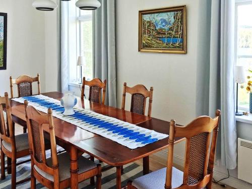 uma sala de jantar com uma mesa de madeira e cadeiras em Holiday home Utansjö em Utansjö