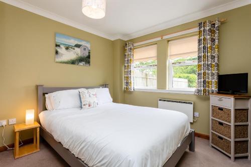sypialnia z łóżkiem i oknem w obiekcie The Apartment w mieście Bamburgh