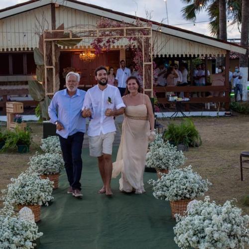 a bride and groom walking down the aisle at their wedding at Pousada Cataventos in Sirinhaém