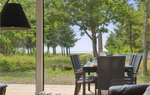 a table and chairs on a patio with a view of the ocean at 3 Bedroom Lovely Home In Hurup Thy in Sønder Ydby