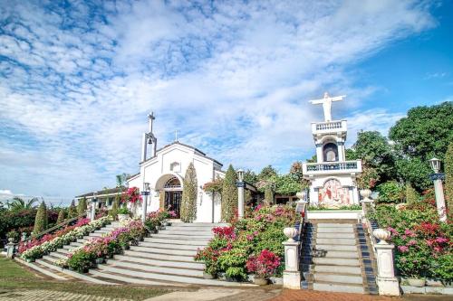 a white church with stairs and a cross at Casa Mercado I in Lipa
