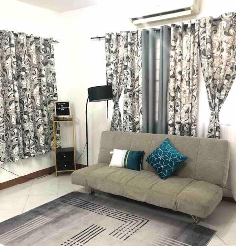 a living room with a couch and curtains at Casa Mercado I in Lipa