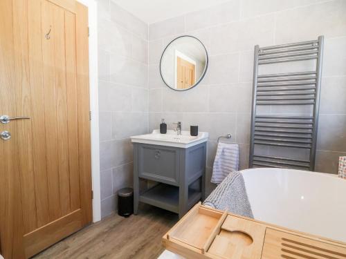 ein Badezimmer mit einer Badewanne, einem Waschbecken und einem Spiegel in der Unterkunft Scottwil in York