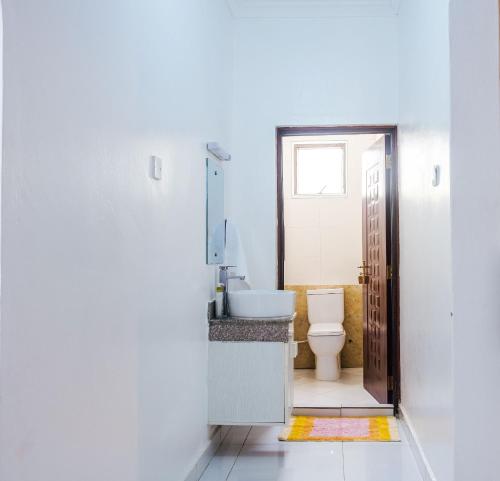 a bathroom with a toilet and a sink at Uhai Vacations in Diani Beach