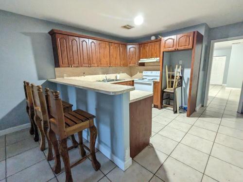 uma cozinha com armários de madeira e uma ilha azul em MiLuSol em Miami