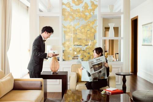 a man and a woman in a living room at The St. Regis Osaka in Osaka