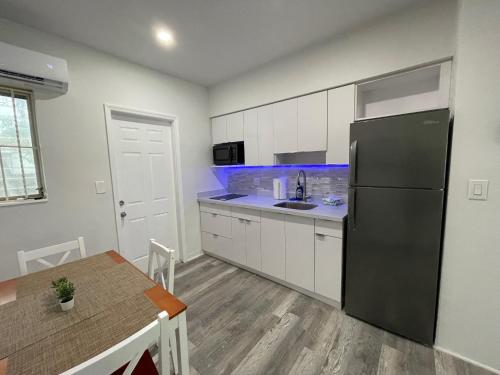 a kitchen with a black refrigerator and a table at Douglas rd apartments in Miami