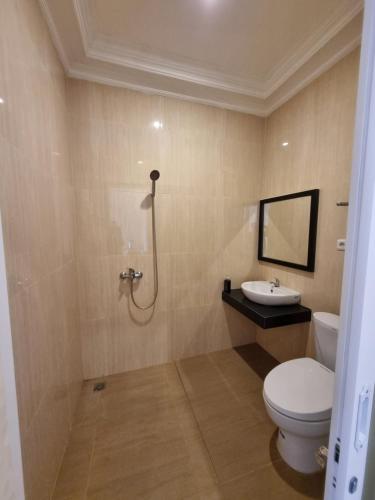 uma casa de banho com um WC e um lavatório em core inn juwita hotel em Kepanjen