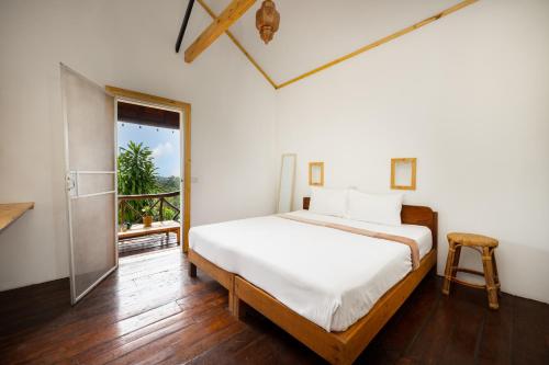 a bedroom with a large bed and a balcony at The Source Yoga and Nature Retreat Koh Phangan in Koh Phangan