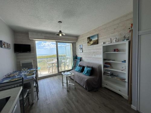 un salon avec un canapé et une table dans l'établissement Appartement cosy avec balcon face mer - Accès plage & parking privé - FR-1-224C-241, à Saint-Jean-de-Monts