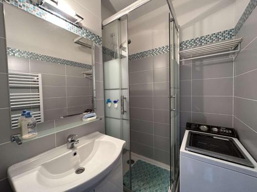 une salle de bain avec un lavabo et une douche en verre dans l'établissement Appartement cosy avec balcon face mer - Accès plage & parking privé - FR-1-224C-241, à Saint-Jean-de-Monts