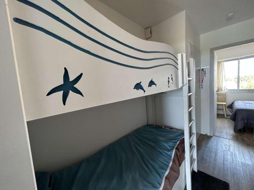 une chambre avec un lit superposé avec des vagues et des dauphins dans l'établissement Appartement cosy avec balcon face mer - Accès plage & parking privé - FR-1-224C-241, à Saint-Jean-de-Monts