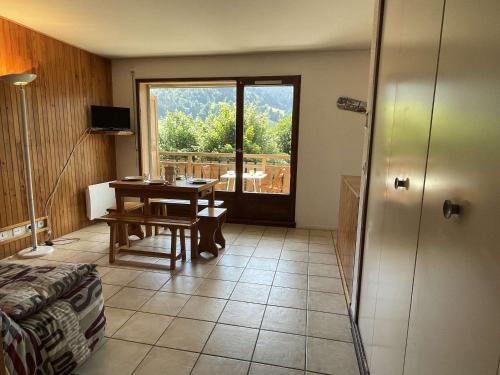 Cette chambre dispose d'une table et offre une vue sur un balcon. dans l'établissement Charmant studio à Praz-Sur-Arly pour 5 pers. proche ski et lac, parking et casier à ski inclus - FR-1-603-79, à Praz-sur-Arly