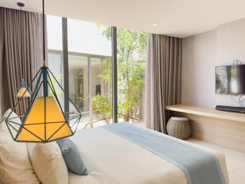 a bedroom with a bed with a yellow lamp at LyGia Villa Long Hải in Long Hai